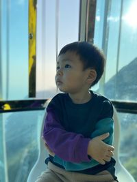 Portrait of asian boy looking away in cable car, hong kong