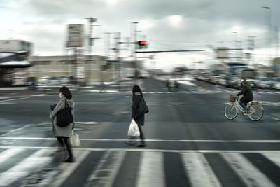 Rear view of people walking on road