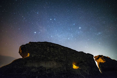 Scenic view of rock formations against sky at night