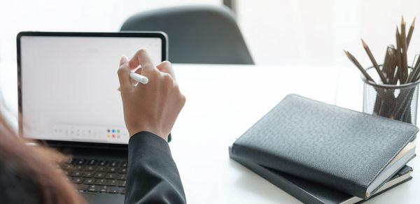 Midsection of man using smart phone on table