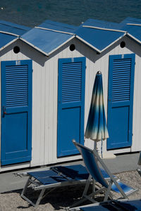 Chairs by swimming pool at beach against buildings