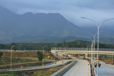 Road by mountains against sky