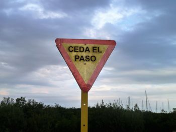 Low angle view of road sign against sky