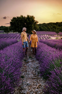 Rear view of women walking on field