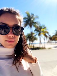 Close-up portrait of woman wearing sunglasses while standing at beach