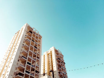 Low angle view of buildings against clear blue sky