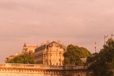 Buildings in city against cloudy sky