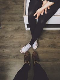 Low section of woman standing on hardwood floor