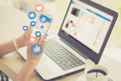 Midsection of man using laptop on table