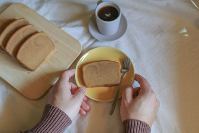 Cropped hand of woman holding coffee on table