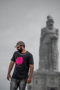 Young man standing statue against blurred background