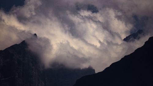 Low angle view of silhouette mountain against sky at sunset