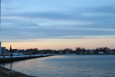 Scenic view of river against sky at sunset