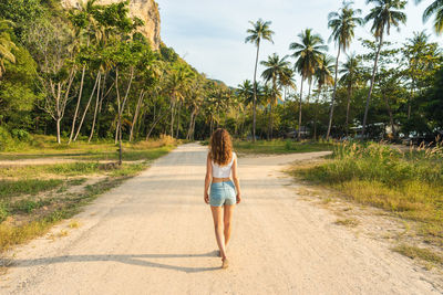 Rear view of woman walking on road