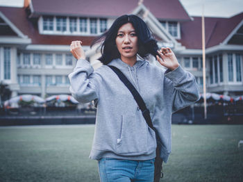 Mid adult woman standing in front of building