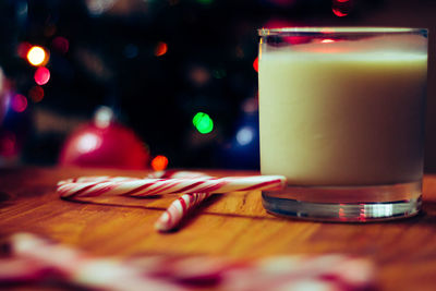 Close-up of drink by candy canes in glass on table