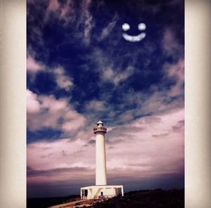 Low angle view of lighthouse against cloudy sky
