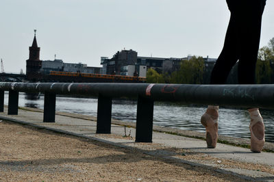 Bridge over river in city against clear sky