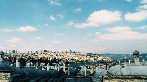 View of cityscape against cloudy sky