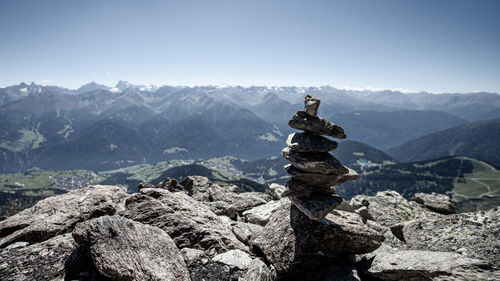 Stack of rocks on mountain against sky