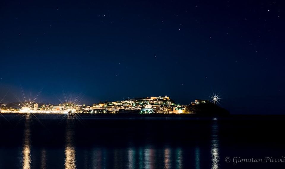 night, illuminated, water, waterfront, city, built structure, sea, architecture, reflection, building exterior, river, cityscape, copy space, clear sky, sky, moon, dark, no people, outdoors, light