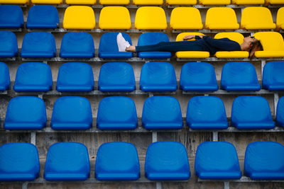 Woman relaxing on seats at stadium