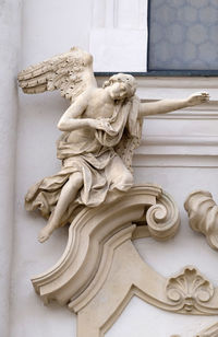 Close-up of angel statue against wall