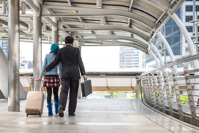 Rear view of people walking in corridor