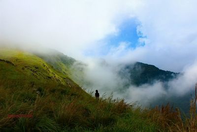 Scenic view of mountains against cloudy sky