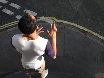 High angle view of man standing on sidewalk in city