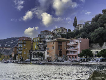 Buildings by sea against sky in city