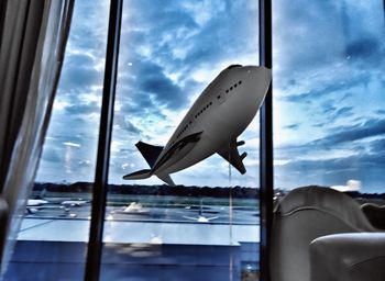 Close-up of airplane window against sky