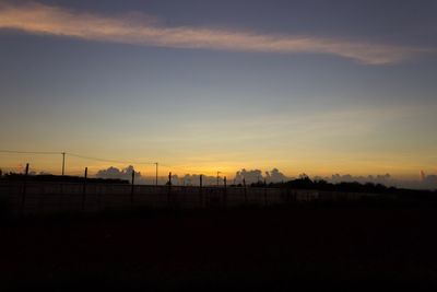 Silhouette beach against sky during sunset