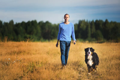 Portrait of man walking with dog on land