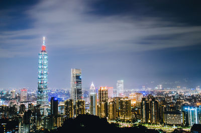 Illuminated buildings in city against sky