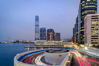 River by illuminated buildings in city at night