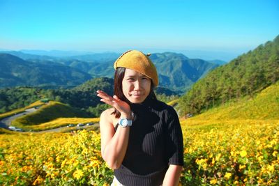 Young woman standing on mountain against sky