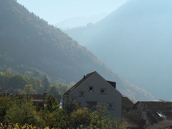 Buildings by mountain against sky