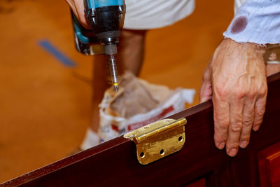 Cropped hand of carpenter fixing door