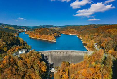 Scenic view of autumn trees by lake against sky