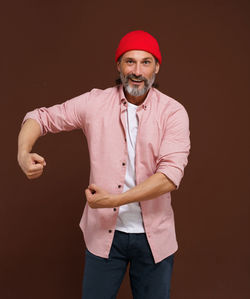Portrait of young man standing against blue background