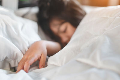 Midsection of woman sleeping on bed