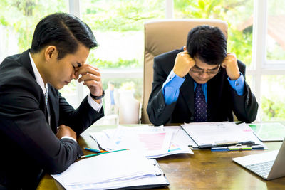 Tensed businessmen at desk in office
