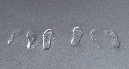 High angle view of shoe prints on sand