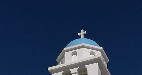 Low angle view of bell tower against blue sky