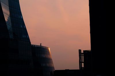 Low angle view of silhouette building against sky