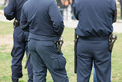 Rear view of people walking on grass