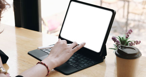 Midsection of person using mobile phone on table