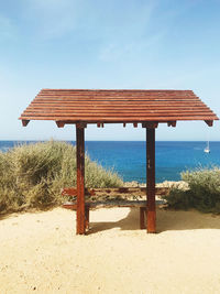 Lifeguard hut on beach against sky