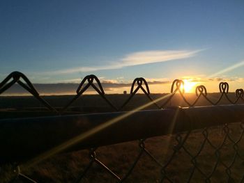 Chainlink fence against sky at dusk